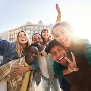 A group of cheerful students college friends taking a selfie as they travel through European cities.