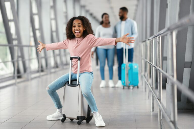 Happy black family traveling with kid, walking in airport